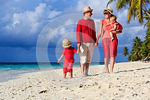 Family with kids walking on tropical beach