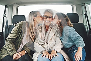 Family, kiss and road trip with a girl, mother and grandmother in the backseat of a car for a drive. Love, travel and
