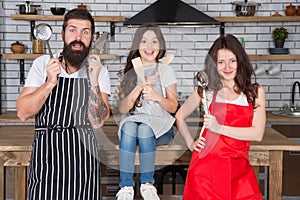 Family in kitchen making breakfast together. small girl have fun with mom and dad. mother father and child cooking