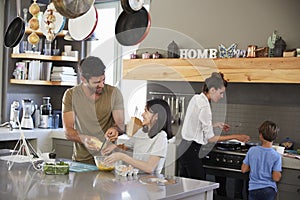 Family In Kitchen Making Morning Breakfast Together