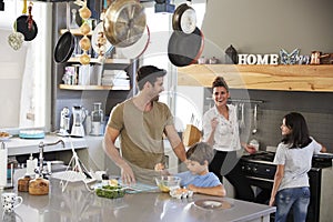 Family In Kitchen Making Morning Breakfast Together