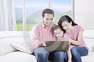 Family with laptop in living room