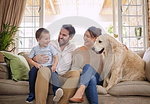 Family laugh, home and dog with child, mom and dad relax on sofa in living room with love. Pet animal, mother and father