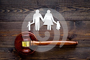 Family law, family right concept. Child-custody concept. Family with children cutout near court gavel on dark wooden photo