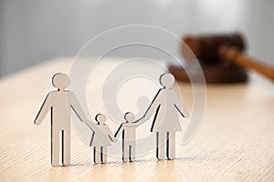 Family law. Figure of parents with children and gavel on wooden table, space for text