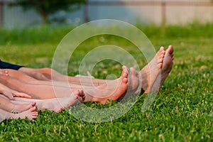 Family legs relaxing on green grass. Whole family resting