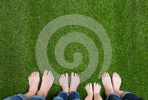 Family legs standing on green grass