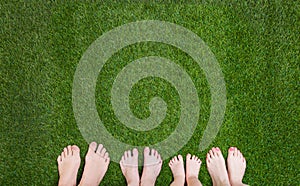 Family legs standing together on green grass