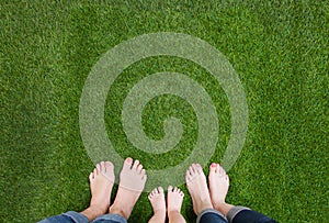 Family legs standing together on green grass