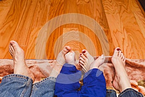 Family legs on a wooden background. baby, mom and dad. Mothers Day. Father& x27;s Day.