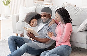 Family Leisure. Man Reading Book With His Wife And Daughter At Home