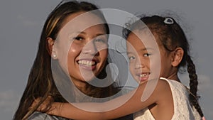 Family, leisure and people concept-close up outdoor portrait of loving mother and small daughter