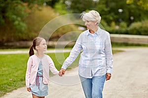 Grandmother and granddaughter walking at park