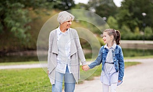 Grandmother and granddaughter walking at park