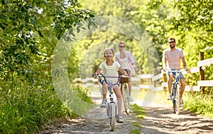 Happy family riding bicycles in summer park