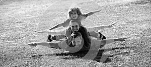 Family leisure time. Family lying on grass in park. Parents giving child piggybacks in park.