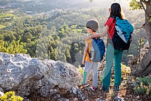 Family lifestyle, mother hugging her son while hiking in the forest, child outdoors on a hike, travel, relax with the child