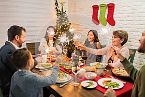 Family Lighting Sparklers While Having Meal At Home