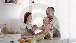 Family With Little Baby Cooking Together In Kitchen, Dad Juggling With Tomatoes