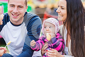 Family with little baby enjoying time at fun fair