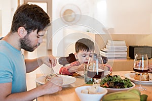 Family with a little child sitting together for lunch