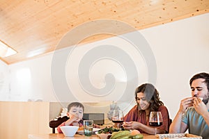 Family with a little child sitting together for lunch