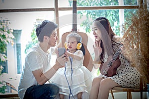 Family with little girl in Listen to music on your phone.
