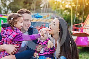 Family with little girls enjoying time at fun fair