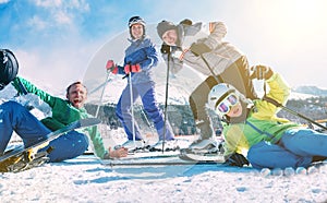 A family with little son dressed ski clothes sincerely smiling and laughing posing for photo on the snow ski hill at the Slovakian