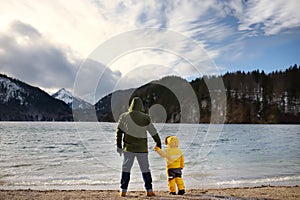 Family with little son enjoy view of lake Alpsee
