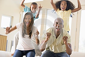 Family in living room cheering and smiling