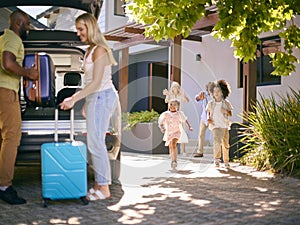 Family Loading Car And Saying Goodbye After Visit To Grandparents