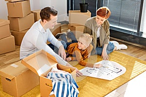 family looking at blueprint planning new home interior design settling in, homeowners talking about remodeling ideas