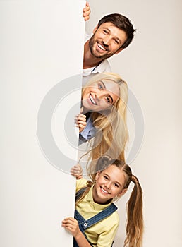 Family Looking Out Of Empty White Board, Studio Background