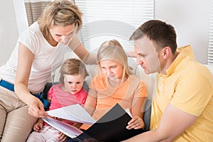 Family Looking At Photos In Photobook