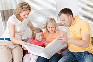 Family Looking At Photos In Photobook