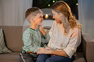 Happy smiling mother talking to her son at home