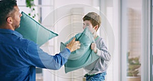 Family, love or pillow fight with a father and son playing in the living room of their home together. Smile, happy or