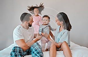 Family, love and relax on bed in home bedroom, having fun or playing. Support, bonding and care of happy father, mother