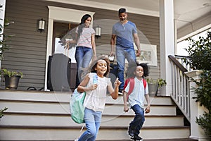 Family With Luggage Leaving House For Vacation