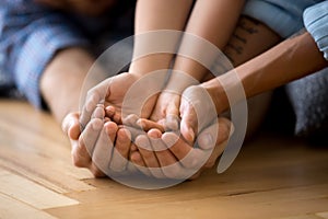 Family lying on floor together holding hands