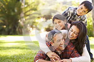 Family Lying On Grass In Countryside