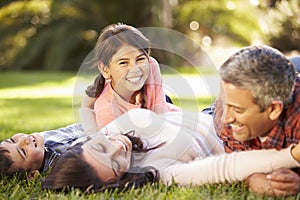 Family Lying On Grass In Countryside