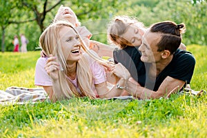 Family lying on grass in countryside