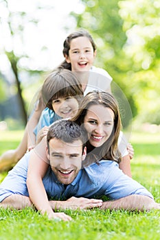 Family lying on grass smiling