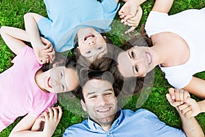 Family lying on grass smiling