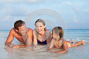 Family Lying In Sea On Tropical Beach Holiday