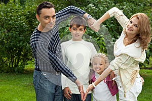 Family making heart symbol from hands outdoors