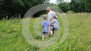 Family, man and children walk among meadows and forests in summer, the concept of family summer vacations, picnics, vacations,