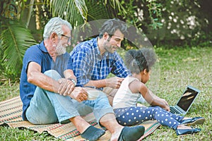 Family man with elder picnic looking happy child care play with daughter at backyard park outdoor